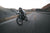 front shot of a man in cool motorcycle gear speeding down the road on a bike